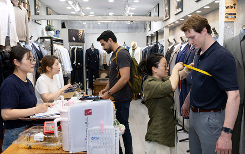 Students on a visit to a tailor's workshop